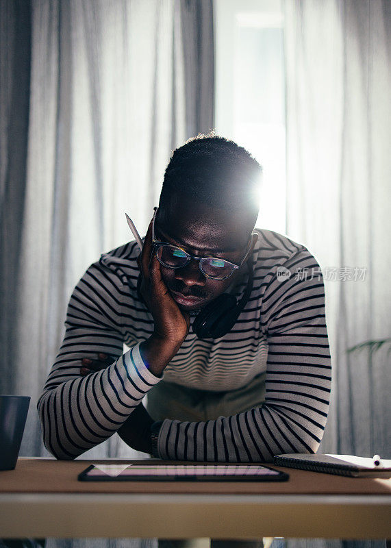 Serious BusinessmanÂ Working At Home On A Digital Tablet